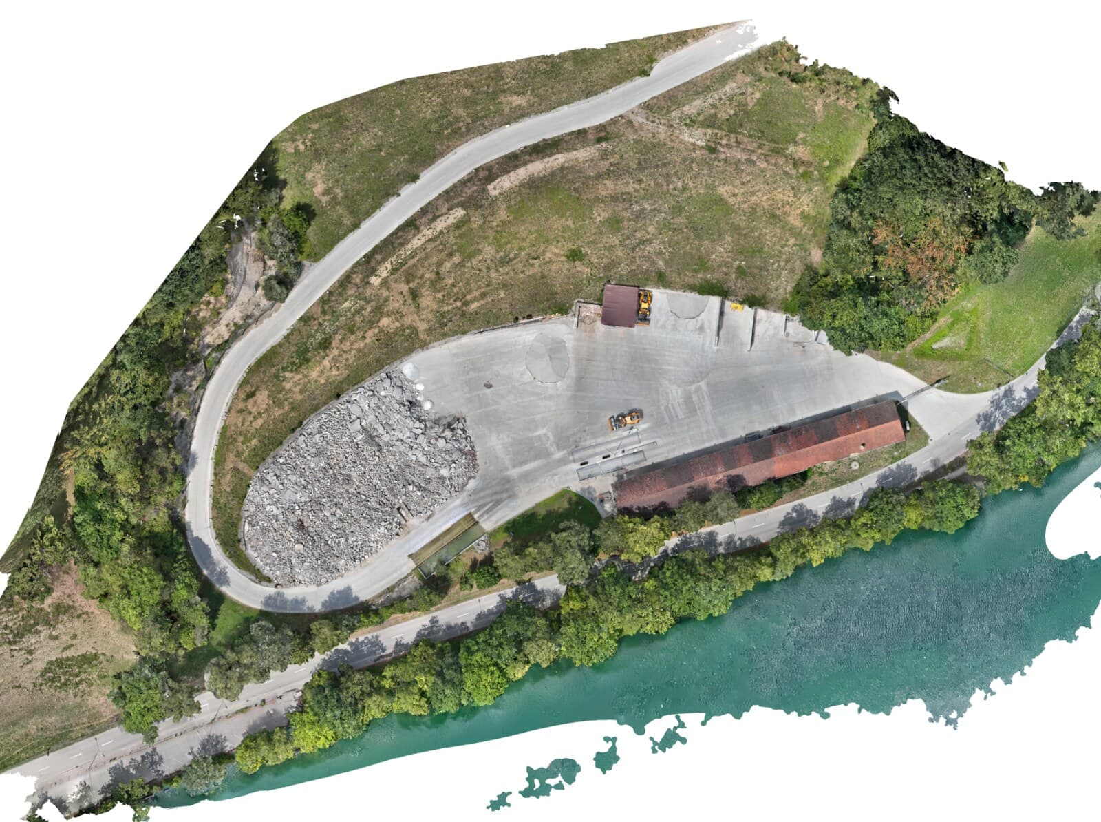 Ortofoto di una discarica ricavata da riprese con drone: strada di accesso, piazzale in calcestruzzo, cumulo di materiale di demolizione e riva del fiume, visti perpendicolarmente dall'alto e in scala